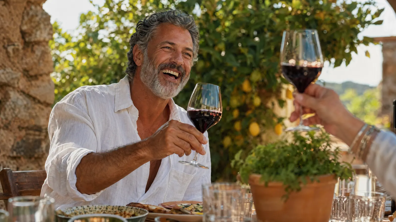 An Allure Dental patient laughing at an outdoor lunch after coordinated cosmetic and restorative dentistry