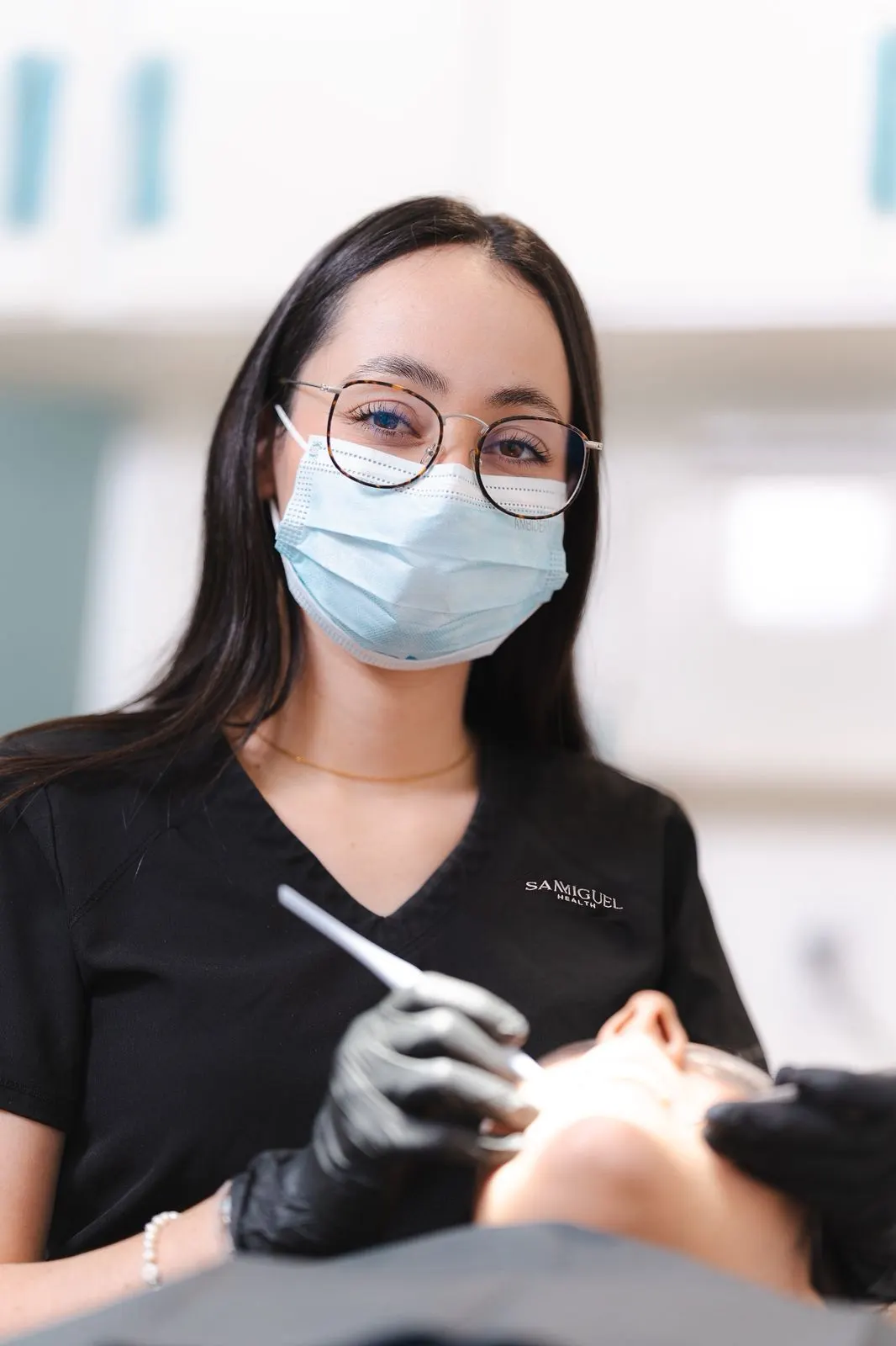 A Dental Team 1 clinical assistant in branded scrubs, professional studio portrait at our Tijuana clinic