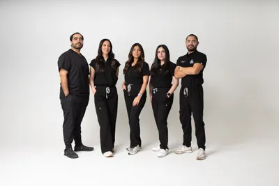 The Highland Dental team in matching black scrubs, warm group portrait