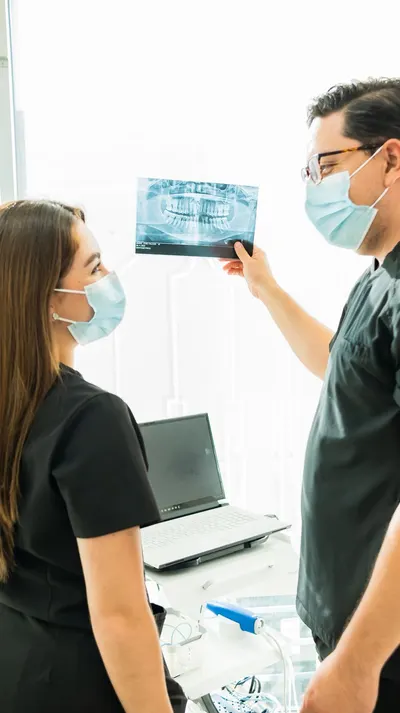 Two dental clinicians reviewing a panoramic X-ray together at San Miguel Dental