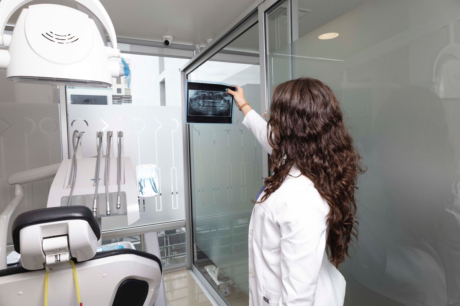 A dental specialist at the partner clinic in Tijuana reviewing a panoramic X-ray for treatment planning.