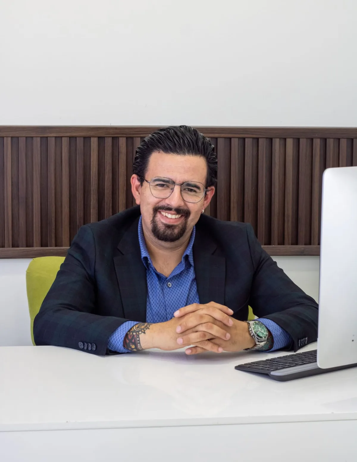 Dr. Eduardo Moreno at his consultation desk, smiling