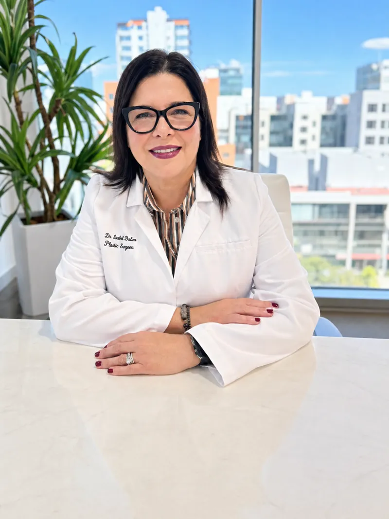 Dr. Isabel Balza, board-certified plastic surgeon, in a white lab coat