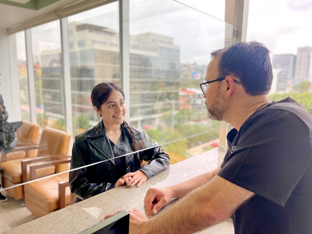 Dr. Casta&ntilde;eda greeting a patient at the consultation desk