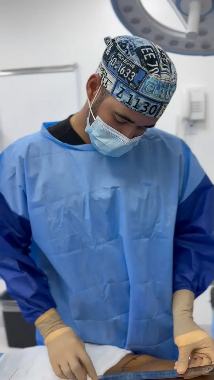 Dr. Luis Monta&ntilde;o working at the operating table during a facial procedure