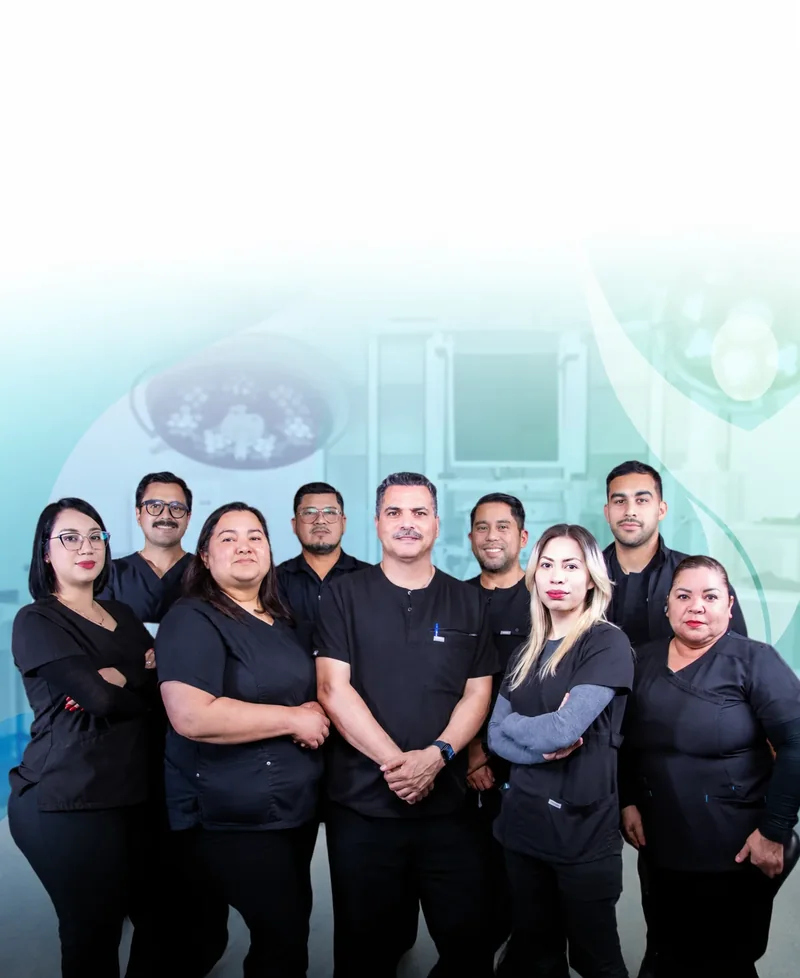 Dr. Mauricio Gutierrez and Dra. Silvia Castillo with their nine-person surgical team in black scrubs beneath the operating-room lights