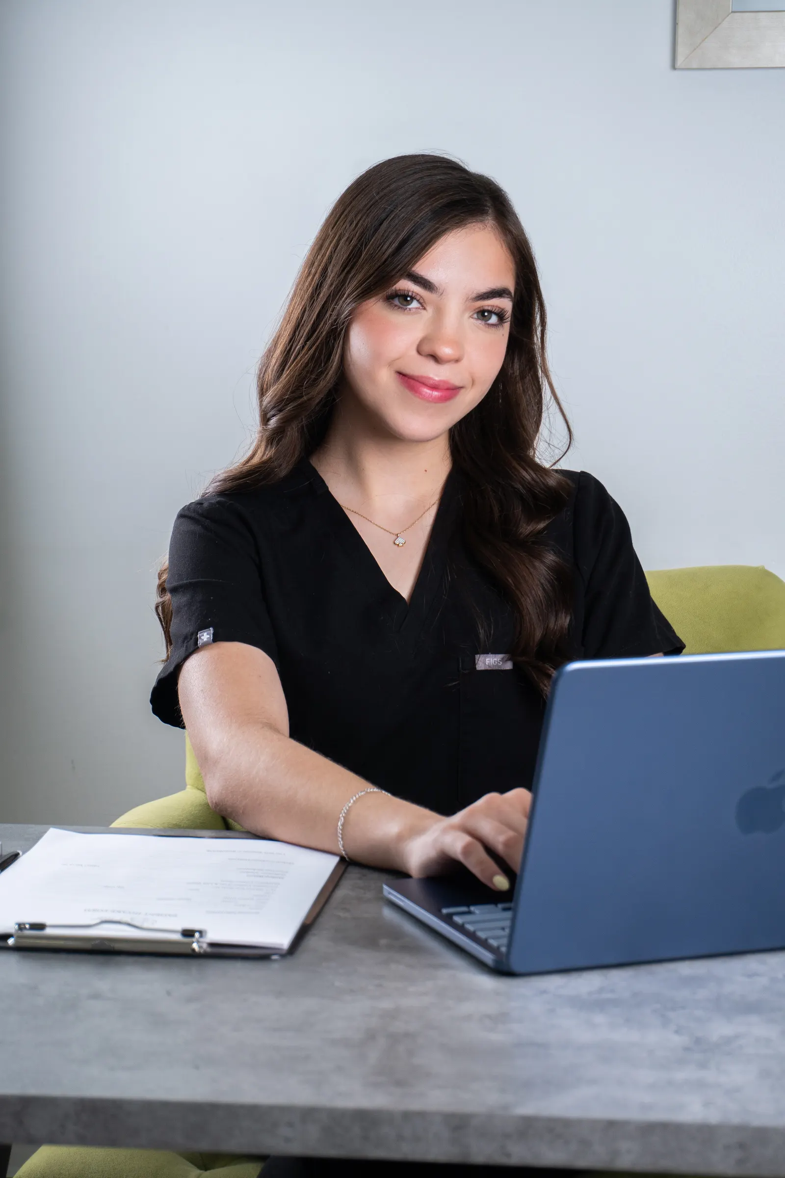 Natalia Gonzalez at her desk on a laptop, following up with patients between consultations