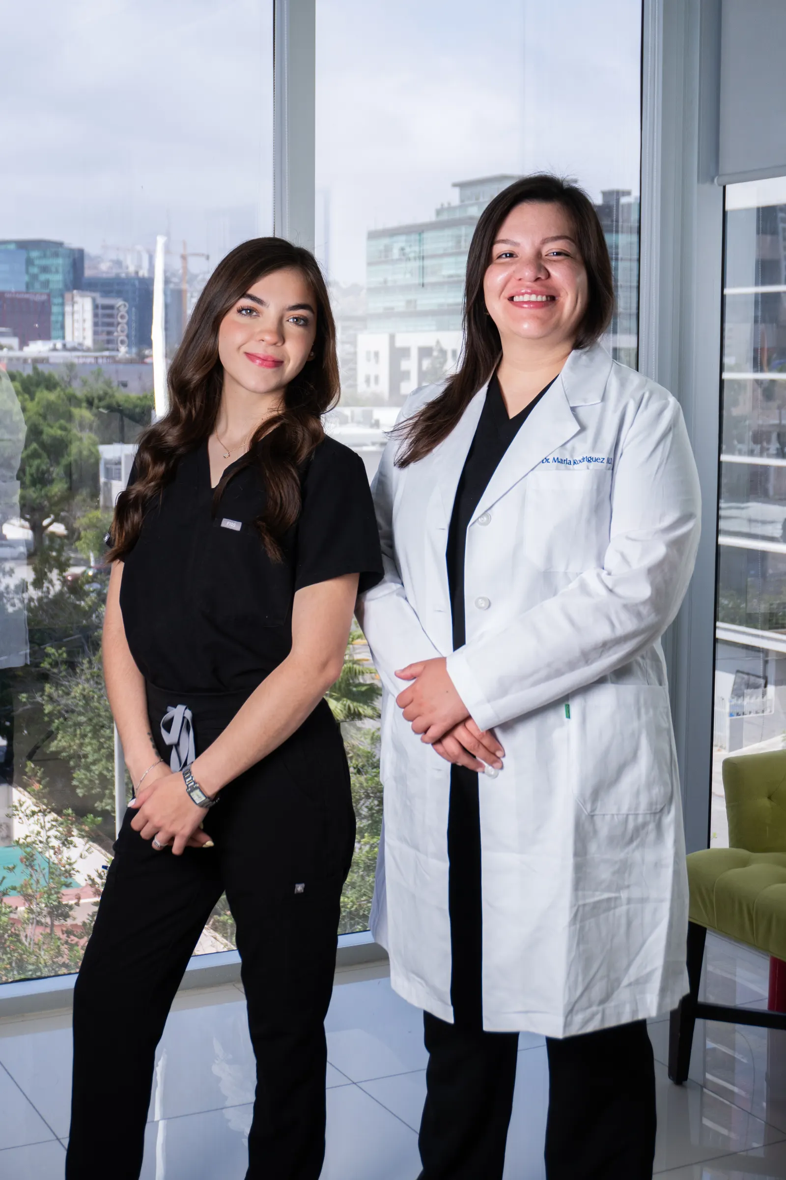 Dra. Marla Rodriguez and Natalia Gonzalez standing side-by-side at the consult window, full smiles