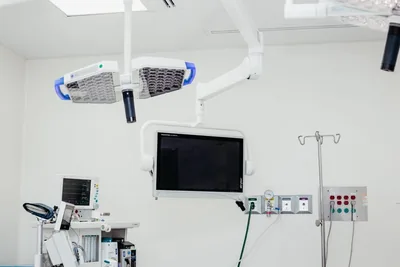 Ceiling-mounted surgical lights and wall monitor inside an operating room at Hospital Bellas Artes