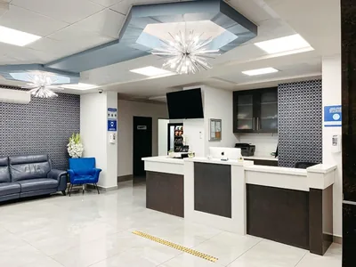 Bright main reception desk at Hospital Bellas Artes with a modern chandelier and patient lounge