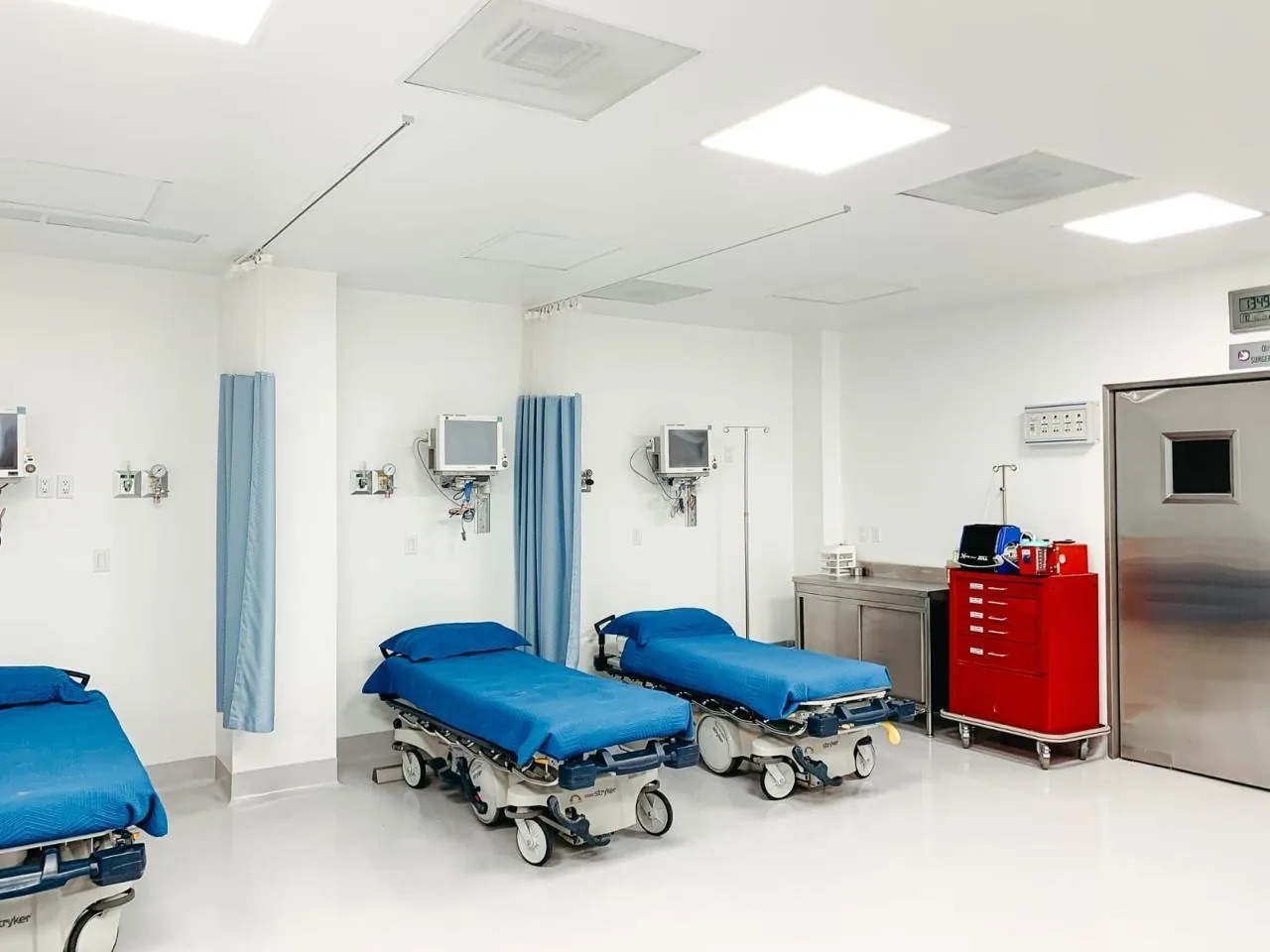 Post-operative recovery bay at Hospital Bellas Artes with stretchers and privacy curtains