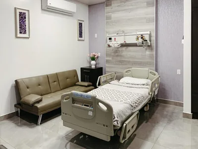 Patient room at Hospital Bellas Artes with a hospital bed and a companion sofa