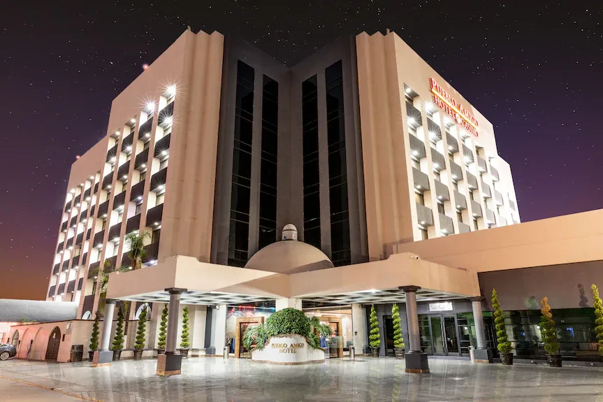 Hotel Pueblo Amigo lit up at night with its covered entrance plaza