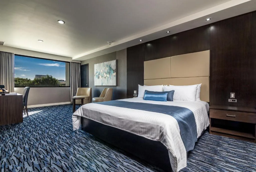 Spacious king room at Hotel Pueblo Amigo with panoramic city window