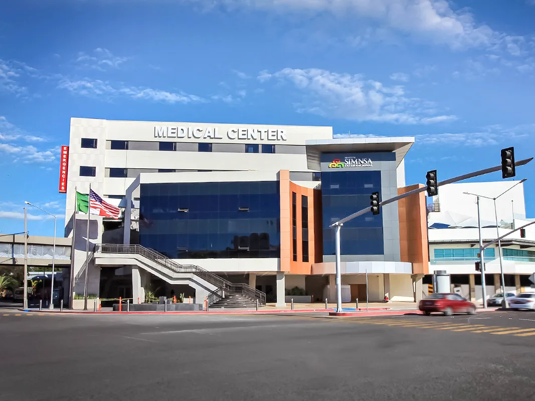 Hospital SIMNSA medical center exterior with American and Mexican flags at the entrance