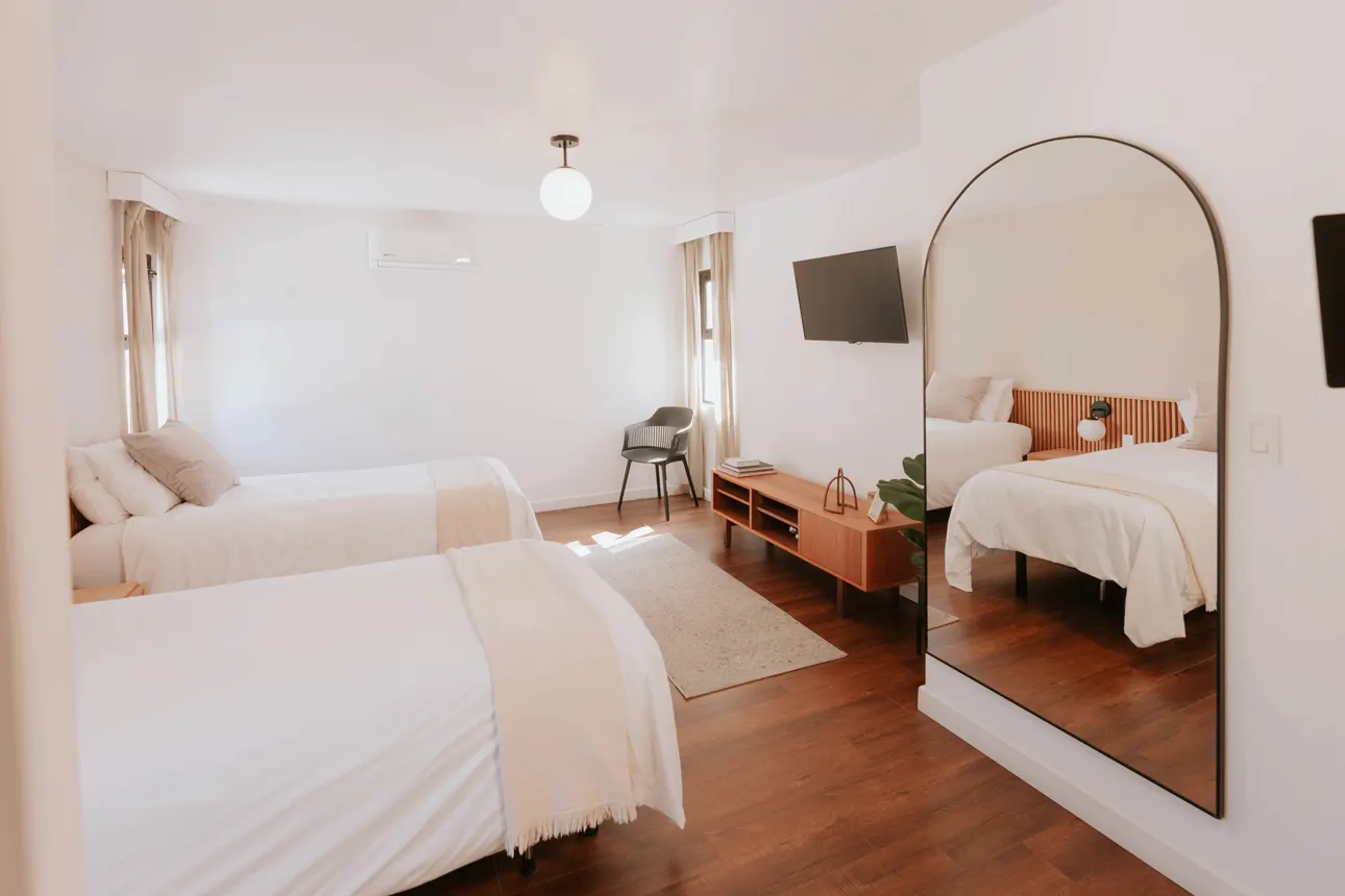 Spacious twin recovery room with wall-mounted Smart TV and full-length mirror